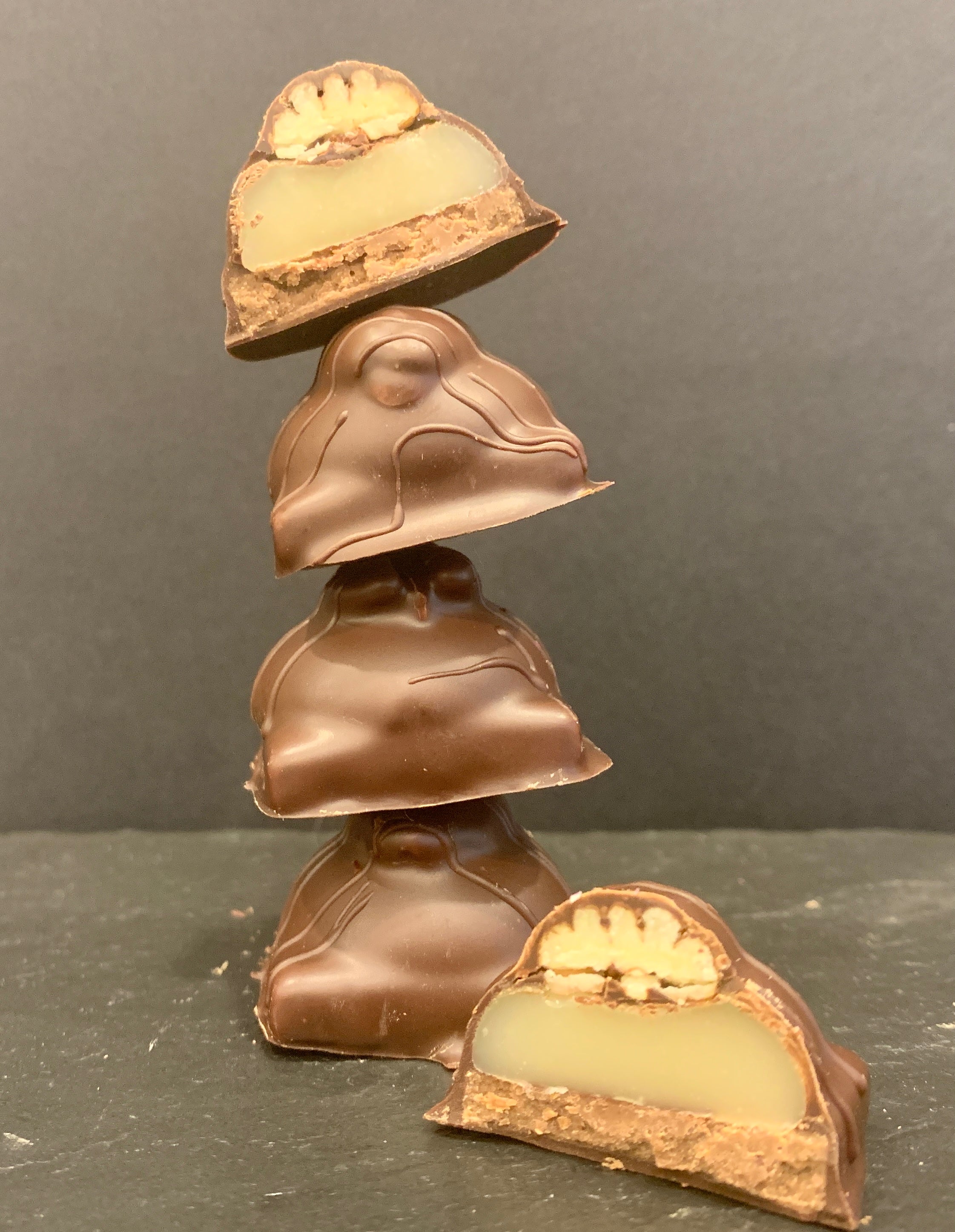 Bouchées tortues, enrobées de chocolat noir ou lait, faites de caramel tendre, praliné à la pacane rôtie et pacane entière sur le dessus.